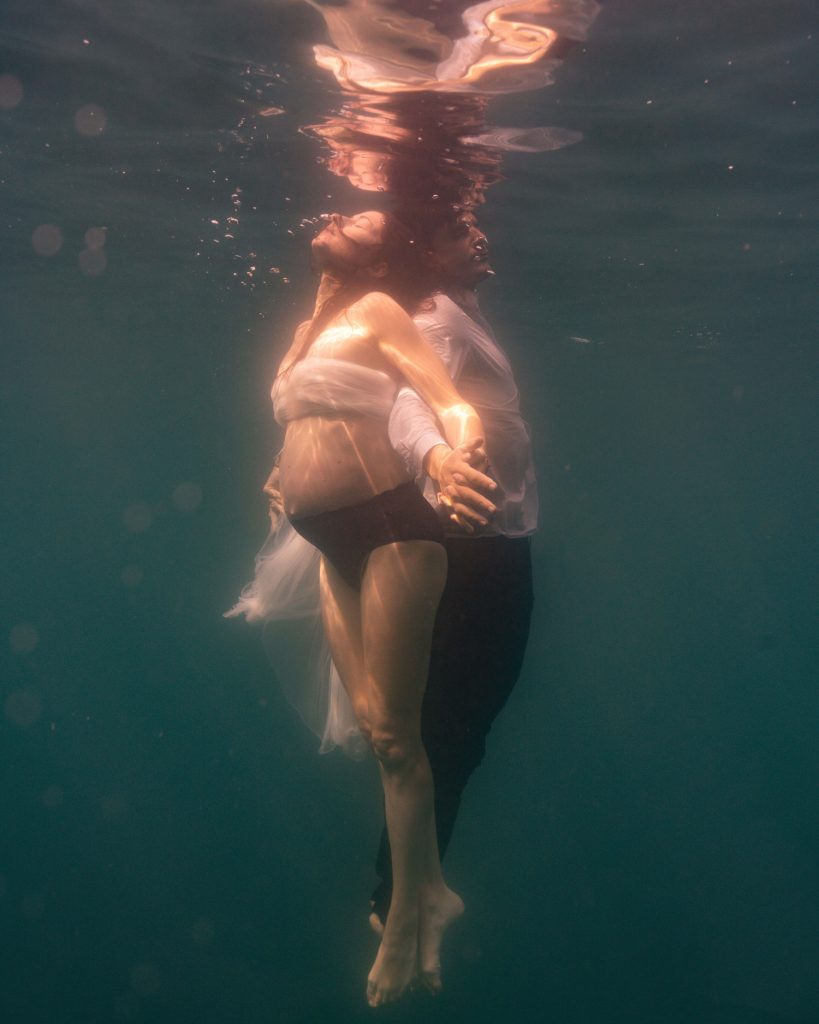 Séance photo aquatique de couple pendant une grossesse en mer à Marseille