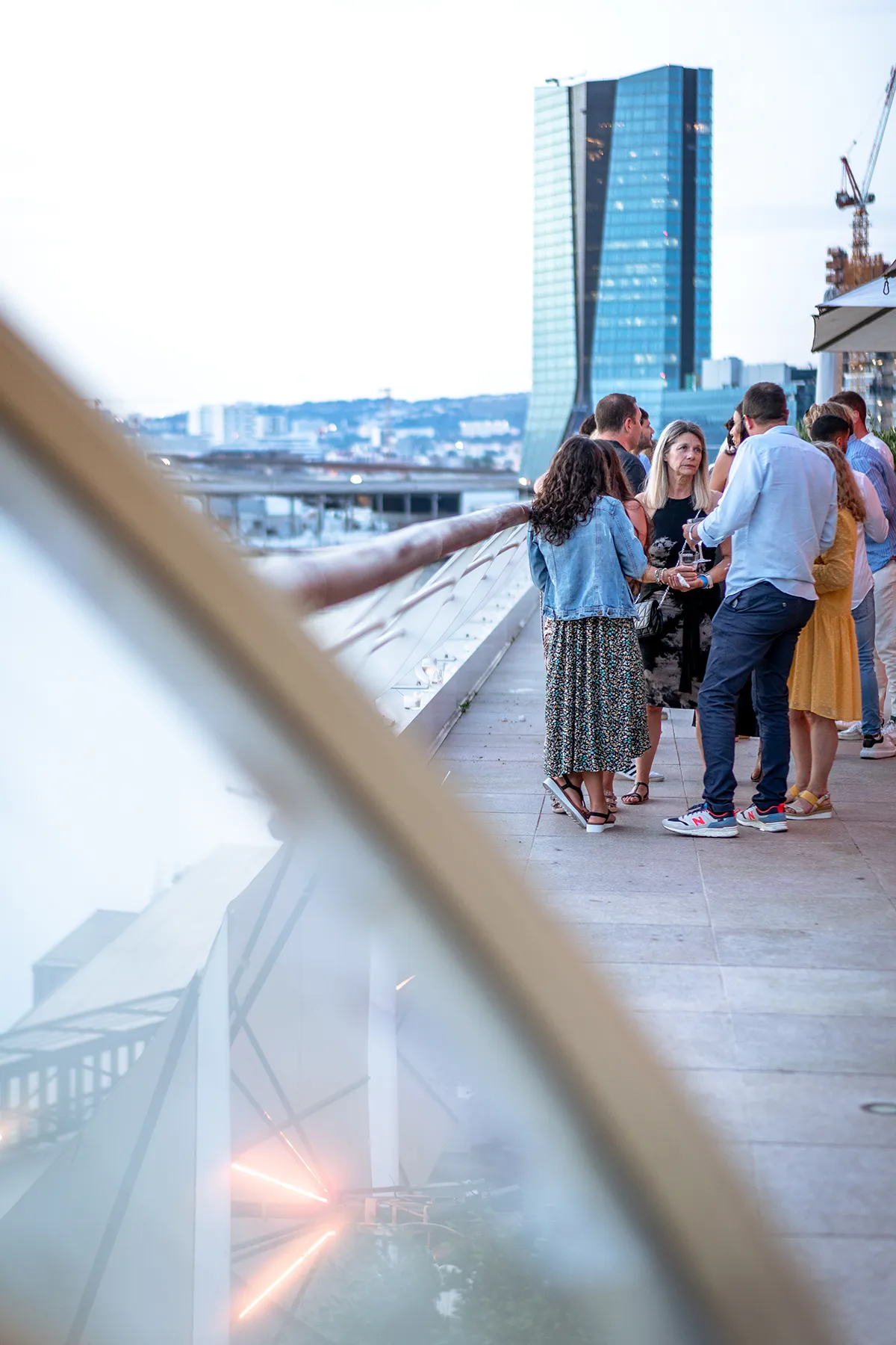 Collaborateurs discutant autour d'un verre lors d'un apéro de séminaire aux Terrasses du Port à Marseille.