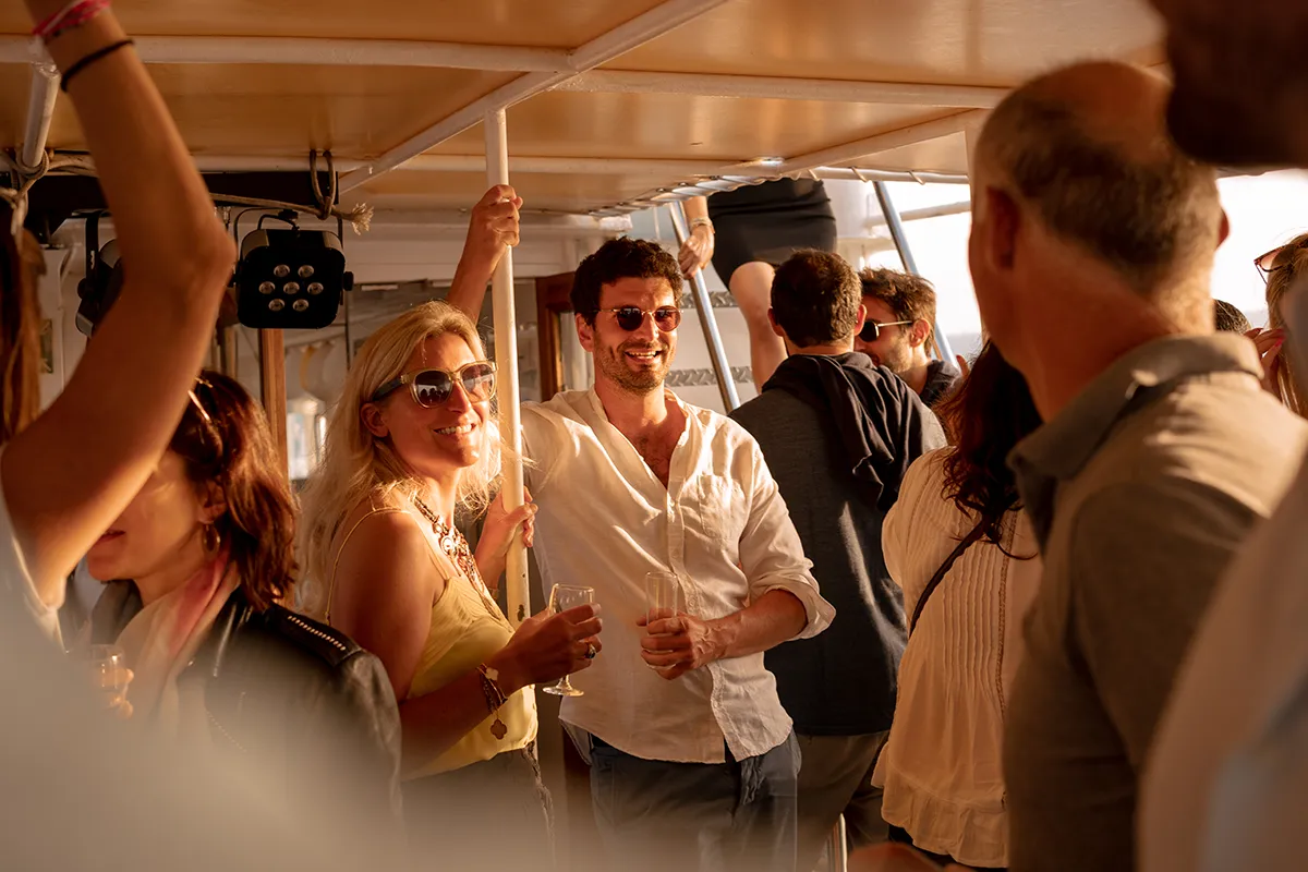 Équipe trinquant avec des verres lors d'un apéro de team building sur un bateau à Marseille.