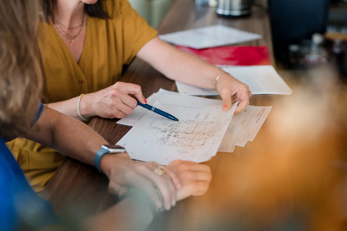 Architecte d'intérieur marseillaise étudiant des plans de rénovation au bureau.