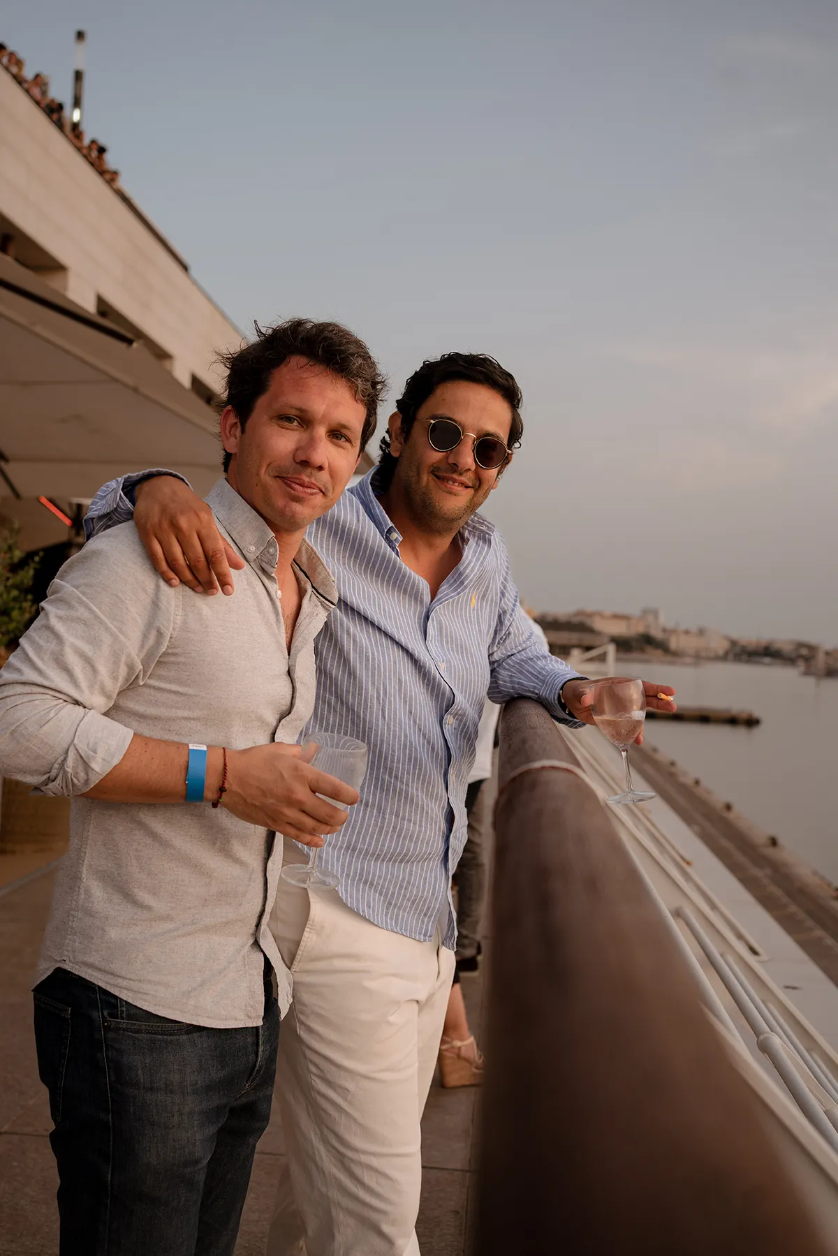 Deux collègues bras dessus bras dessous admirant le coucher de soleil, ambiance conviviale d'un team building à Marseille.