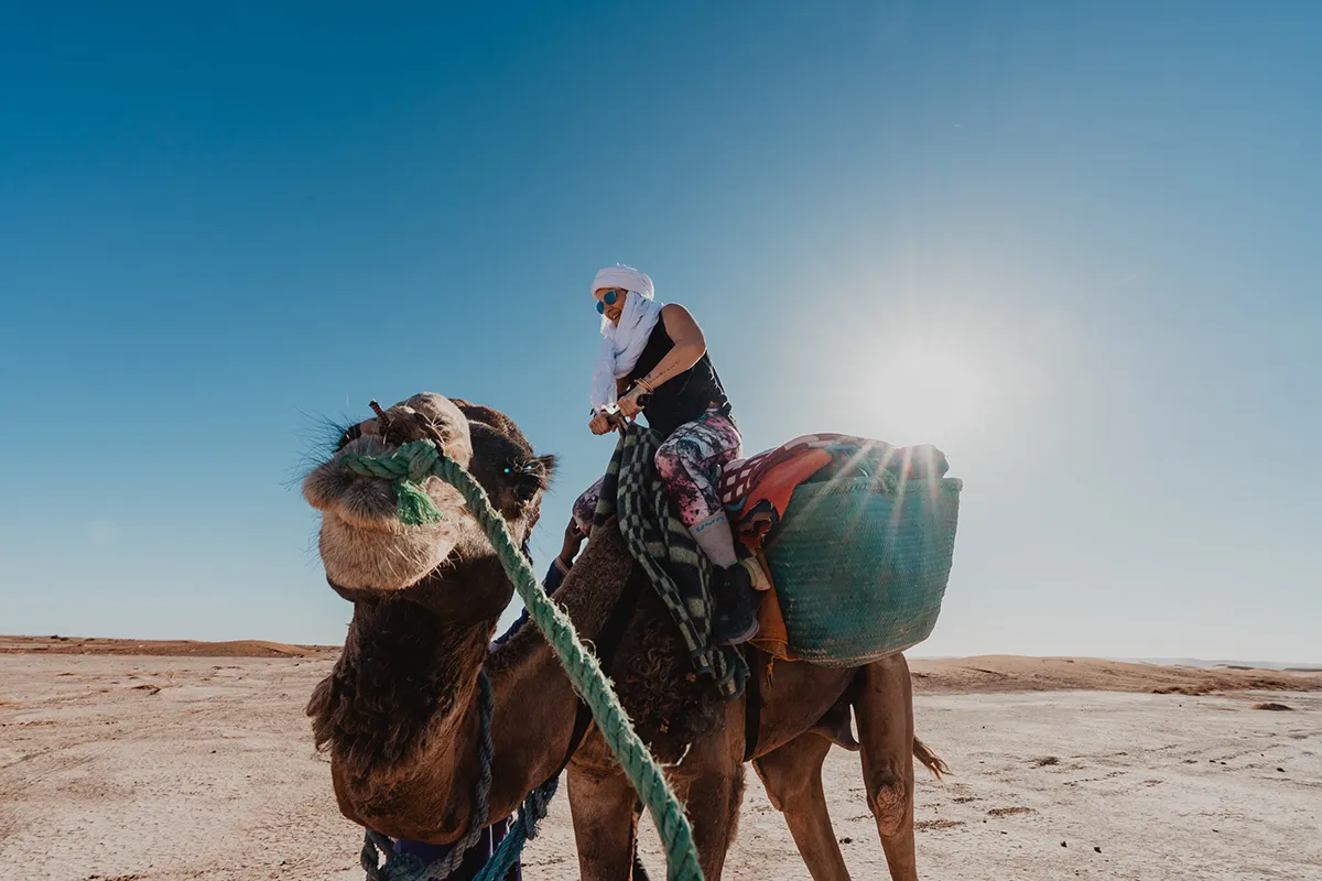Participant sur un dromadaire pendant une retraite yoga au Maroc