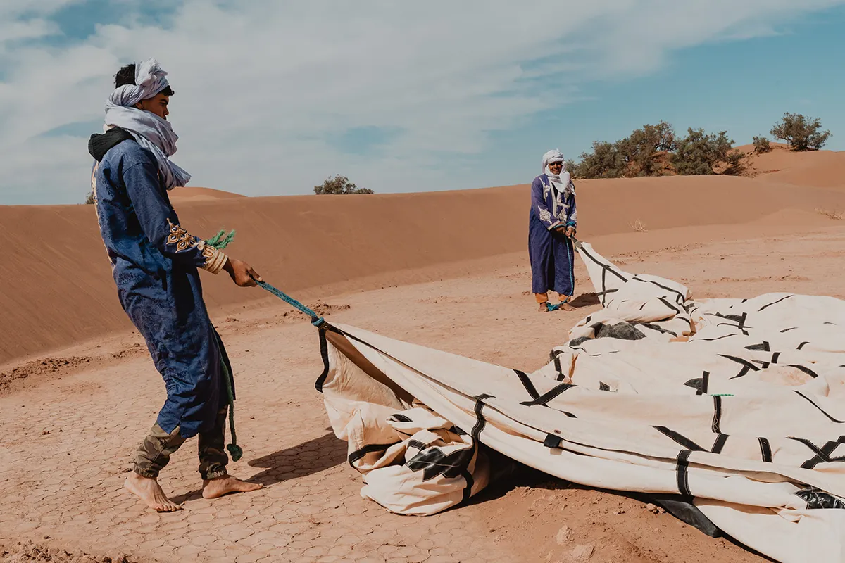 Photographe retraite yoga Maroc lors de l’installation de la caravane dans le désert à M’Hamid El Ghizlane