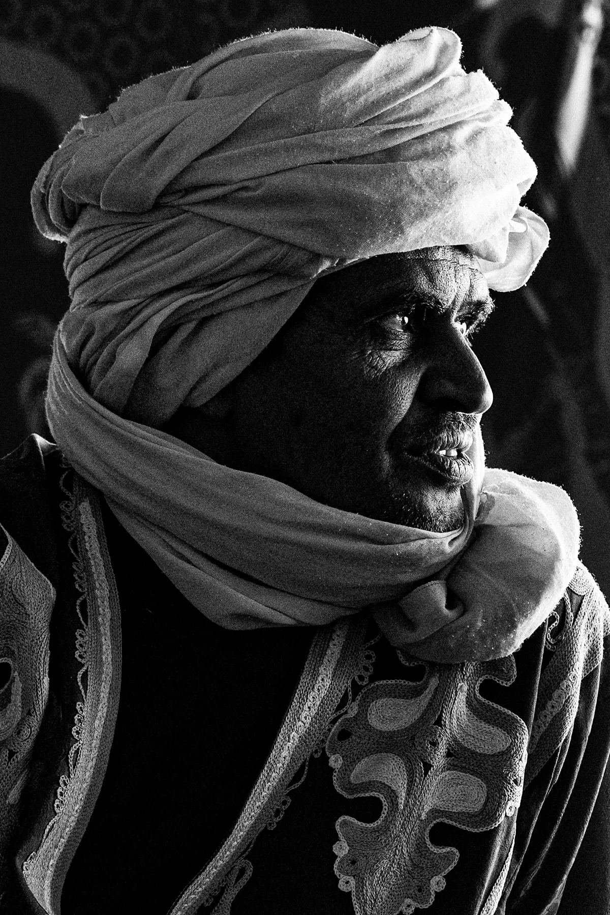 Portrait noir et blanc d’un bédouin dans le désert marocain