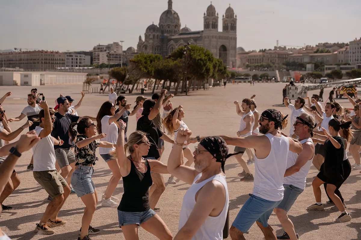 Coach Sara Fallah encadrant une activité sportive avec les collaborateurs CBRE sur le parvis de la Major à Marseille