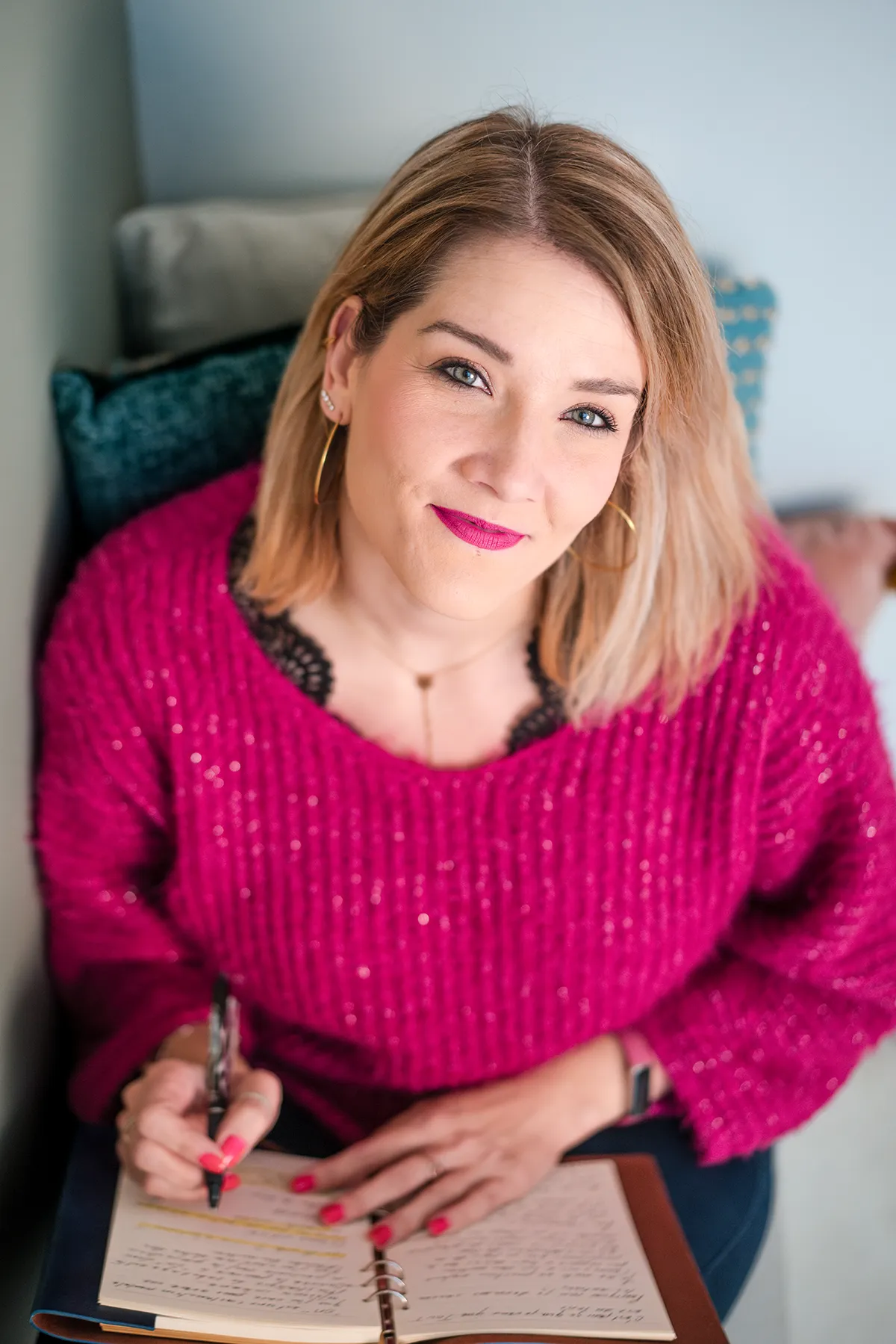 Vanessa souriante en train d'écrire des solutions sur son carnet, illustrant la créativité et la positivité lors d'un shooting photo coach Marseille.