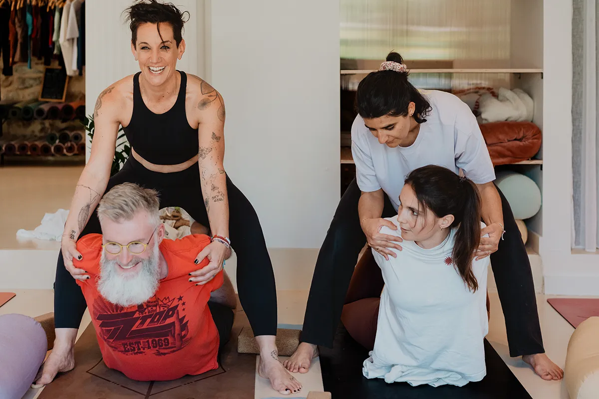 Groupe de yogis riant aux éclats pendant un cours, ambiance décontractée, shooting photo studio yoga Aix-en-Provence.