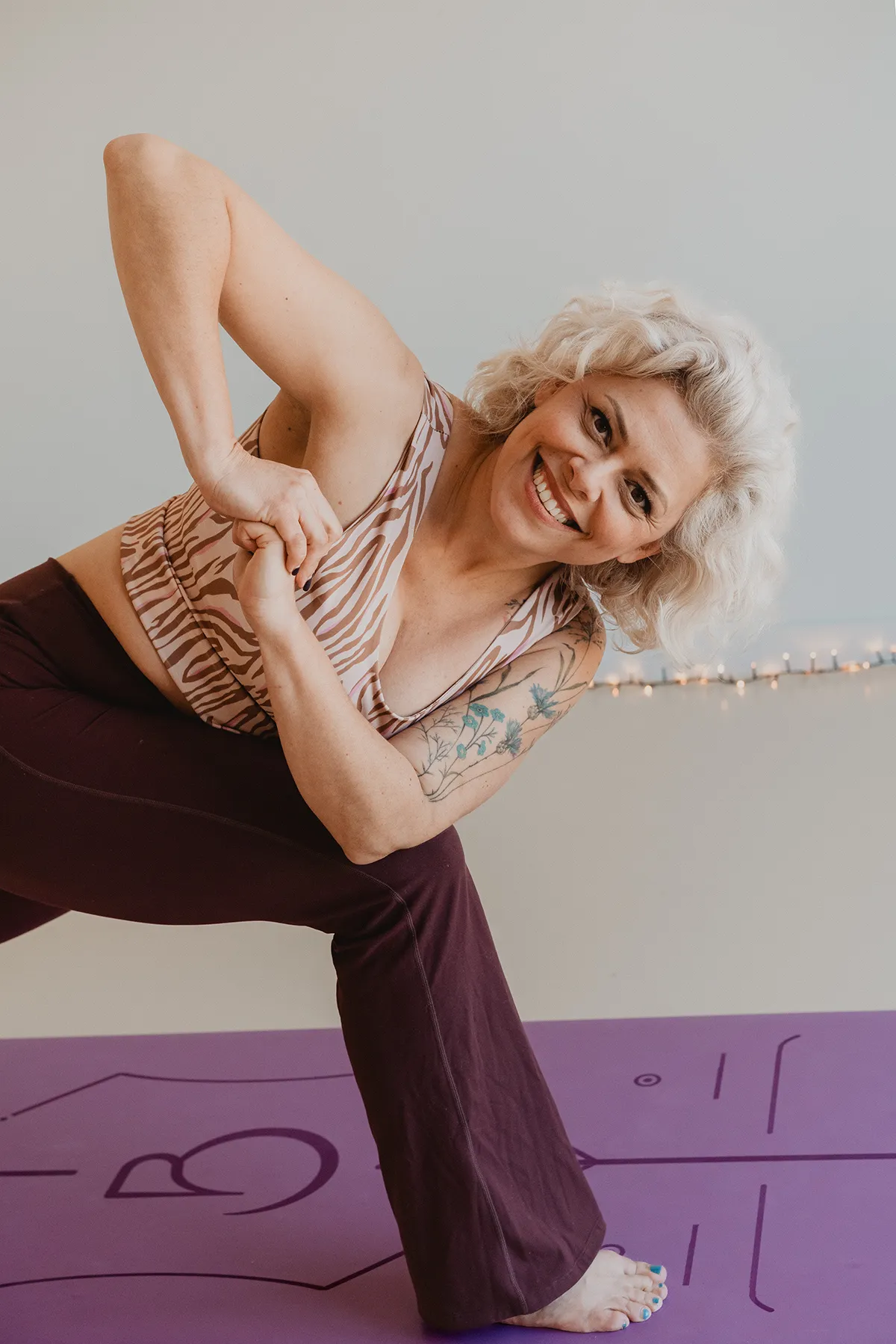Femme souriante en posture du guerrier, cours de yoga dynamique à Aix-en-Provence, photographe spécialisée yoga.