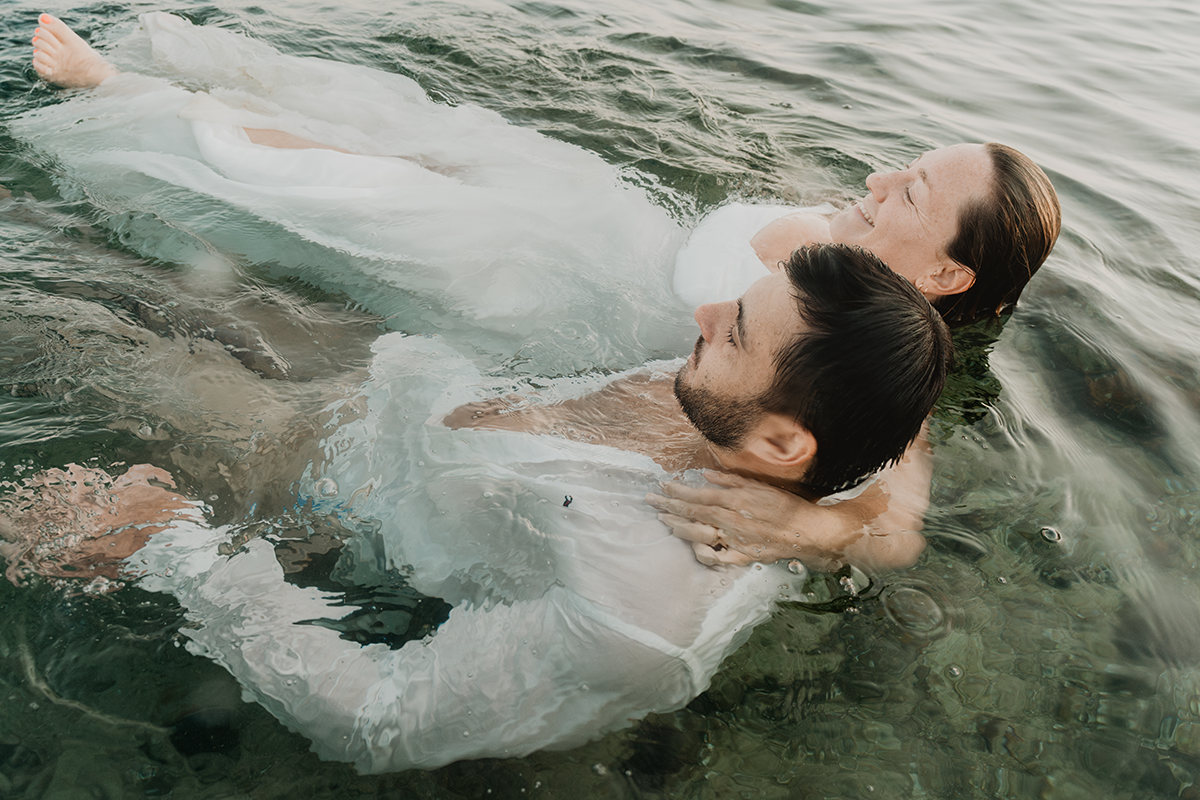 Couple de mariés lors d'une séance photo sous l'eau, transition mi-eau mi-air à Marseille, début d'immersion