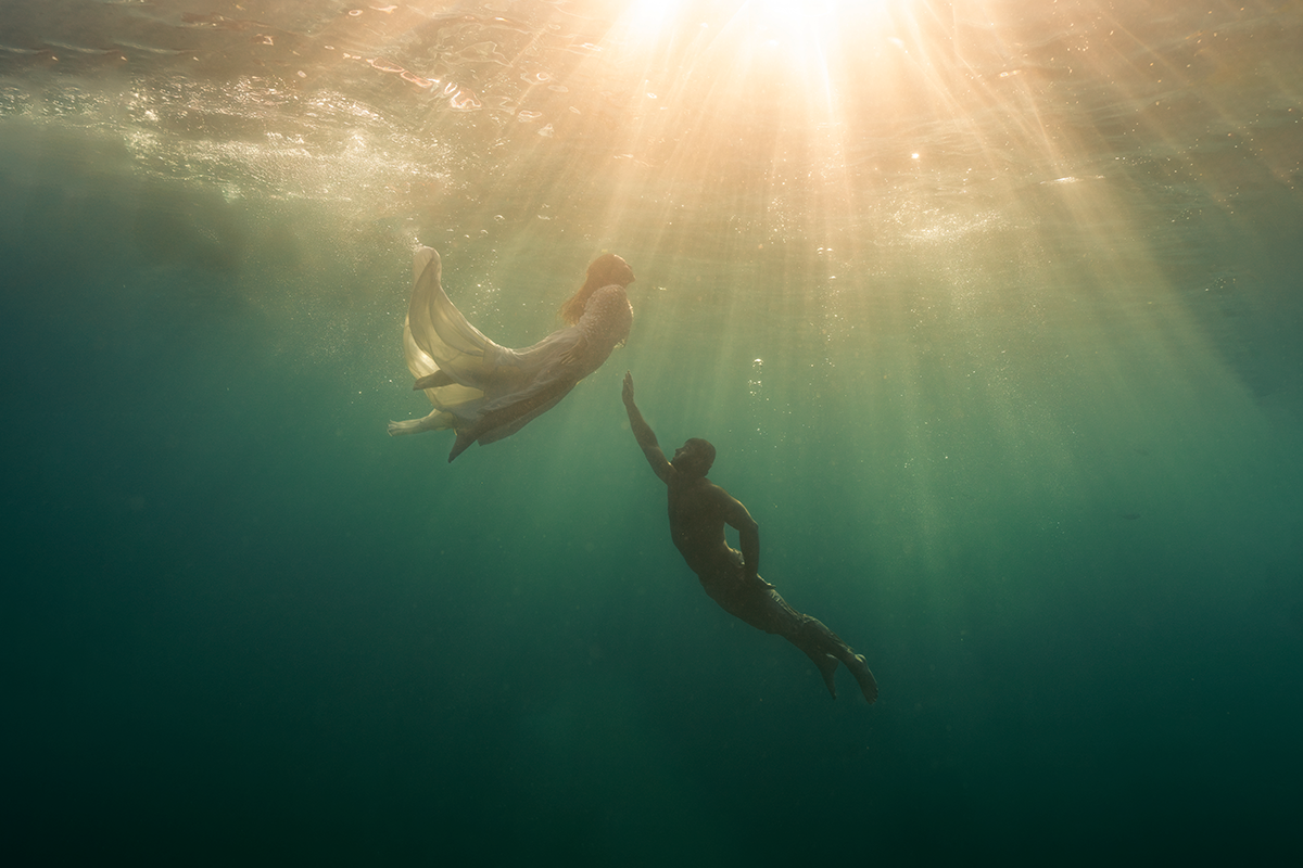 Rayons de soleil traversant l'eau (sunburst) lors d'une séance photo mariage sous l'eau, lumière naturelle à Marseille.